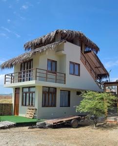 uma casa grande com um telhado de palha em cima em Bungalow Villa Alive em Los Órganos