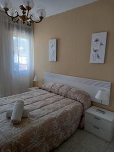 Un dormitorio con una cama grande y una lámpara de araña. en Albergue Agarimo, en Caldas de Reis