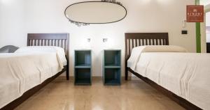 two beds sitting next to each other in a room at Dimore Anna Maria -Il Magazzino- in Avola