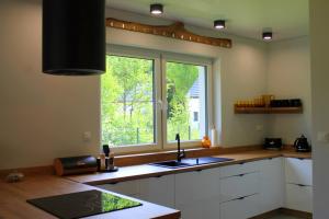 una cocina con fregadero y ventana en BetullaHouse, en Nakielno