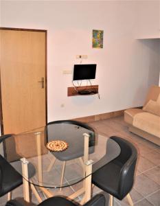 - un salon avec une table en verre et un canapé dans l'établissement Apartments Dvije Palme, à Šibenik