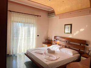 a bedroom with a large bed and a window at Green Garden Villa in Durrës