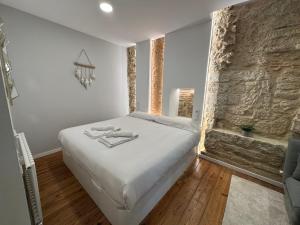 a bedroom with a bed and a stone wall at Oktheway Marina in A Coruña
