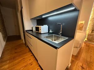 eine Küche mit Spüle und Mikrowelle in der Unterkunft Oktheway Marina in A Coruña