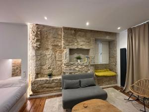 ein Wohnzimmer mit einer Couch und einer Steinwand in der Unterkunft Oktheway Marina in A Coruña