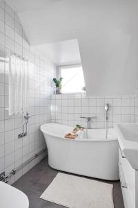 a white bathroom with a tub and a sink at Amazing family home in Stockholm in Stockholm