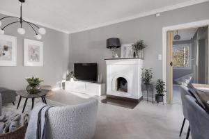 a white living room with a fireplace and a tv at Amazing family home in Stockholm in Stockholm