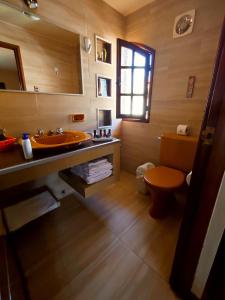 een badkamer met een wastafel, een toilet en een spiegel bij Hotel Boutique La Casa de Margarita in Cochabamba