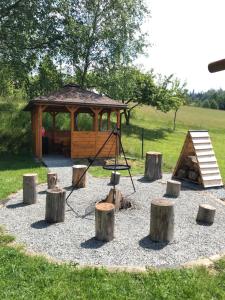 einen Spielplatz mit Holzscheiten und einem hölzernen Pavillon in der Unterkunft Domki u Oli in Kudowa-Zdrój