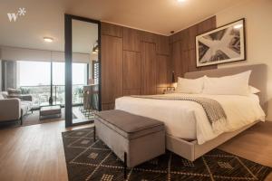 a bedroom with a large bed and a balcony at El Sol by Wynwood House in Lima