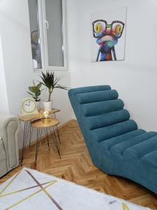 a living room with a blue chair and a table at Big Apartment Veles in Veles