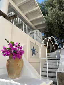 een vaas gevuld met paarse bloemen naast een trap bij Art B&B in Panarea
