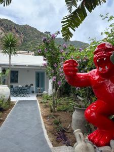 une statue d'ours rouge devant une maison dans l'établissement Art B&B, à Panarea