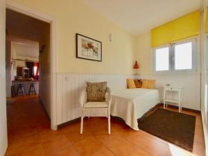 a bedroom with a bed and a chair at sunrise directly at the sea in La Mareta