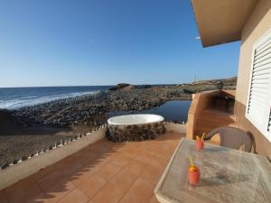 a patio with a bath tub on the beach at sunrise directly at the sea in La Mareta