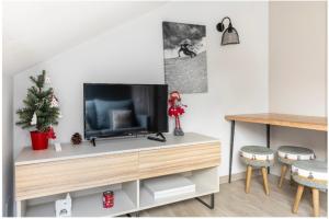 sala de estar con mesa y TV en CHIC HUMARALET, estudio a pie de pistas, en Baqueira Beret