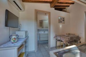 uma cozinha com um lavatório e uma sala de jantar com uma mesa em La Casina di Alan - Goelba em Porto Azzurro