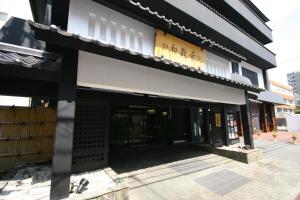 un bâtiment avec un panneau sur son côté dans l'établissement Wasuki Tsukasakan, à Kumamoto