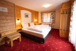 a hotel room with a bed and a red carpet at Tirolerhof - Super Sommer Card included in Serfaus