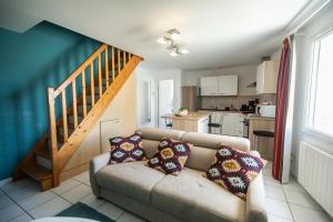 ein Wohnzimmer mit einem Sofa und einer Treppe in der Unterkunft Le Dixmude, appartement proche plage de Morgat in Crozon