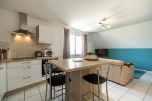 eine Küche mit einem Tisch und Stühlen im Zimmer in der Unterkunft Le Dixmude, appartement proche plage de Morgat in Crozon