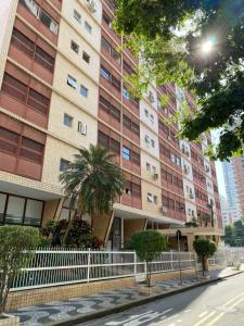 a tall building with a white fence in front of it at Studio Gonzaga 1 Quadra da Praia in Santos