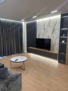 sala de estar con sofá y TV de pantalla plana en Emi Apartment, en Durrës