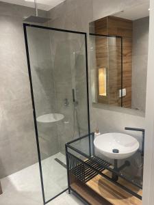 a bathroom with a glass shower and a sink at Emi Apartment in Durrës