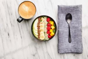 eine Schüssel Salat mit Obst und eine Tasse Kaffee in der Unterkunft Sheraton Dallas Hotel in Dallas