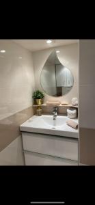 een badkamer met een wastafel en een spiegel bij Appartement en bord de mer in Fos-sur-Mer