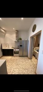 cocina con nevera de acero inoxidable y fregadero en Appartement en bord de mer, en Fos-sur-Mer