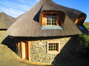 Casa con techo de paja y ventana en Liphofung cave, chalets, en Butha-Buthe