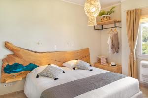 een slaapkamer met een groot bed met 2 kussens bij PENNY LUXURY APARTMENTS in Kokkari