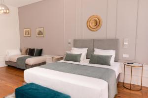 une chambre d'hôtel avec deux lits et un canapé dans l'établissement Quinta dos Tojais, à Castelbuono