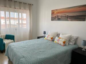 a bedroom with a bed and a painting on the wall at Confort Apartment 2 Bedrooms in Alhos Vedros