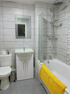 a bathroom with a toilet and a sink and a bath tub at Mayflower House Barnsley-Wombwell-3 Bedrooms-2 Showers-Longer Stay- Free Parking in Barnsley