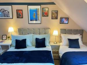 - une chambre avec 2 lits et des photos sur le mur dans l'établissement Mayflower House Barnsley-Wombwell-3 Bedrooms-2 Showers-Longer Stay- Free Parking, à Barnsley