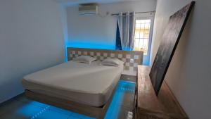 uma cama num quarto com uma parede azul em Appartement TUWA em Koungou