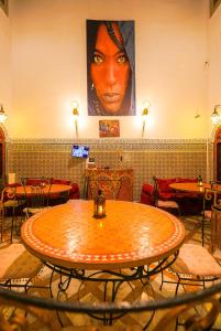 une grande table dans une pièce avec des tables et des chaises dans l'établissement Riad Sahraui, à Fès