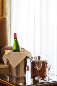 a bottle of wine in a bucket on a table with glasses at Varanda Do Mar in Panaji