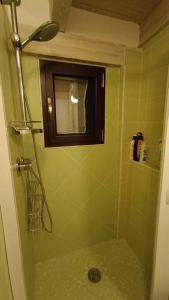 La salle de bains verte est pourvue d'une douche et d'une fenêtre. dans l'établissement Casa Torre dell'Angelo, à Bitonto