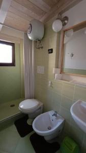 La salle de bains est pourvue de toilettes blanches et d'un lavabo. dans l'établissement Casa Torre dell'Angelo, à Bitonto