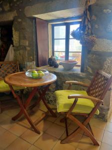 uma mesa e cadeiras numa cozinha com uma janela em Cerca de la playa, con bodega, terraza y jardin Camino Portugués em A Guarda