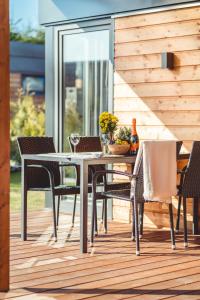 a dining table and chairs on a deck at RResort - nowe KLIMATYZOWANE domki z PODGRZEWANYM Basenem, Sauna, WiFi, parking w cenie! in Rewal