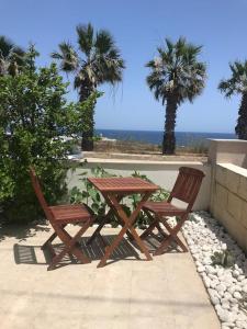 a picnic table and two chairs with the ocean in the background at Seafront, 2 bed apartment in quiet central area in Pembroke