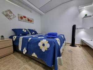 a bedroom with a blue and white bed and a sink at Hospedaje Casa Leví in Cali