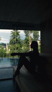 a person sitting on a porch looking out a window at Hotel Podgorie Spa in Bukovel