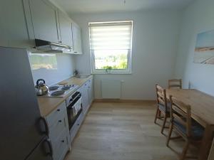 a kitchen with a table and a stove top oven at Apartament Stogi in Gdańsk