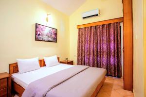 Schlafzimmer mit einem Bett und einem Fenster in der Unterkunft 'Golden Sea Breeze' Beach villa in Benaulim