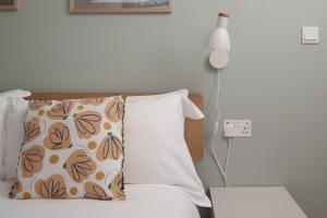 a bedroom with a bed with a pillow and a lamp at Contemporary First Floor Apartment Central Penzance in Penzance
